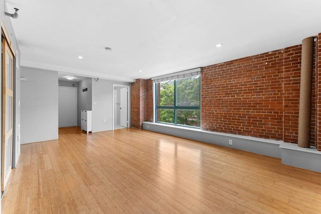 42 8th St Unit 1301, Boston, MA 02129 - unfurnished living room featuring brick wall, light wood finished floors, and recessed lighting