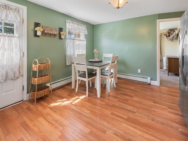 dining area with baseboard heating and light wood finished floors