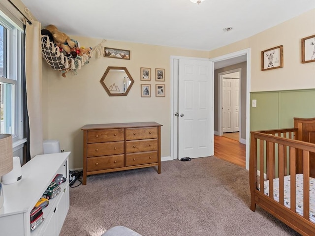 carpeted bedroom with a crib