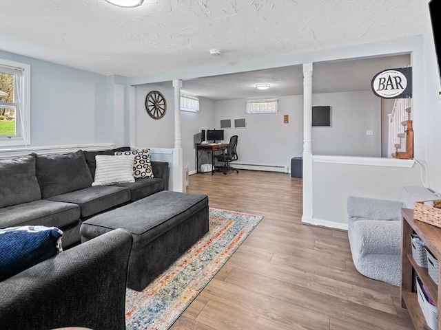 living area featuring light wood-style floors, baseboards, and baseboard heating