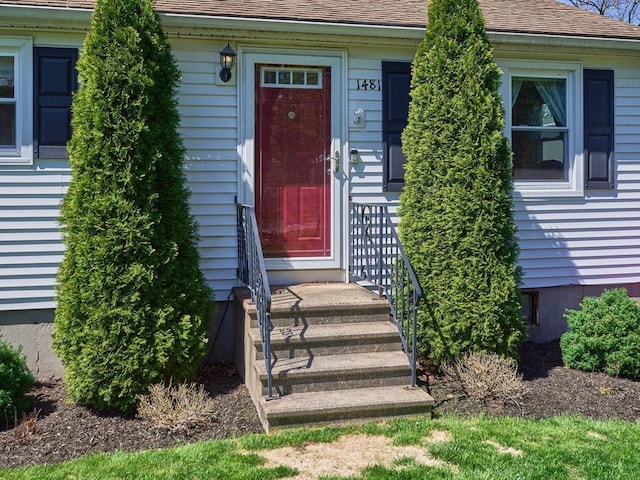 entrance to property featuring a shingled roof