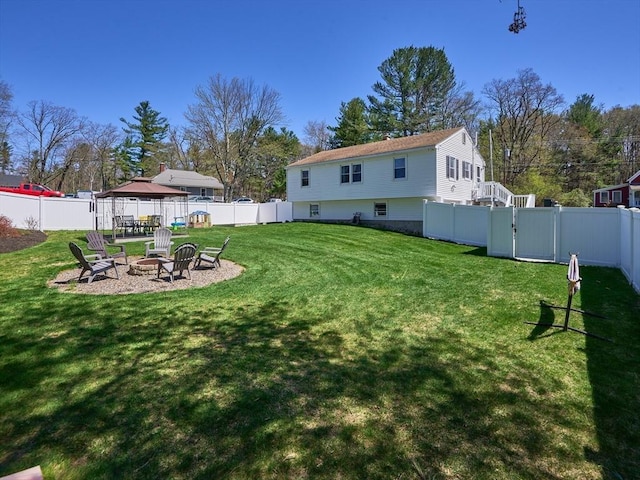 view of yard featuring a fenced backyard and a fire pit