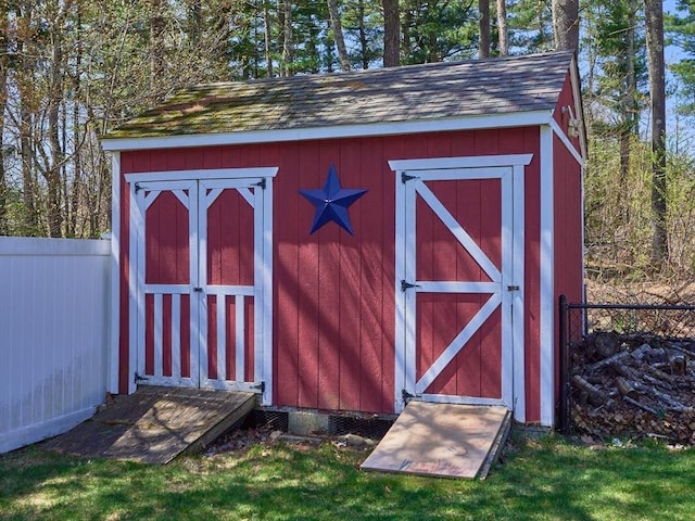 view of shed featuring fence