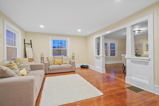 living room featuring ornate columns and hardwood / wood-style floors