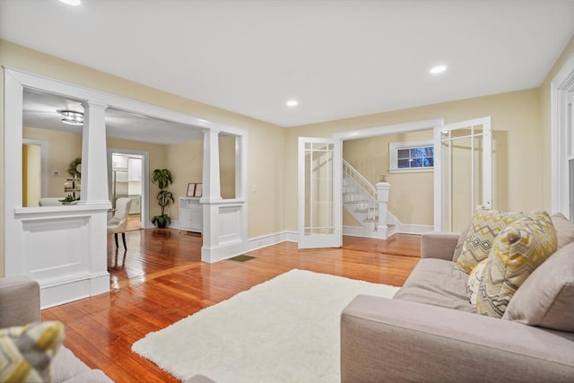 living room with ornate columns and wood-type flooring