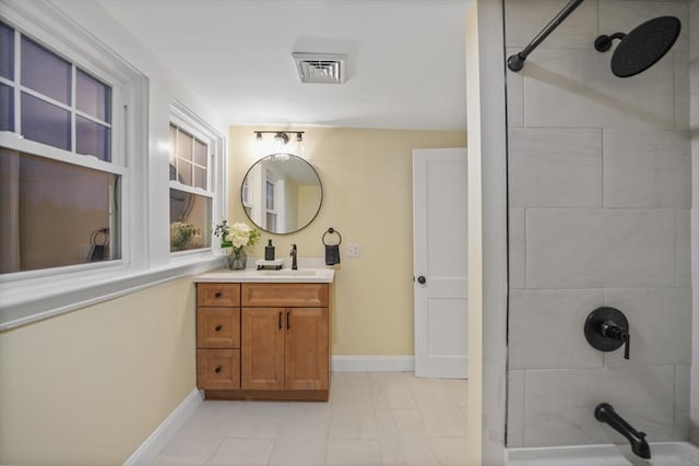 bathroom with tiled shower / bath, vanity, and tile patterned floors