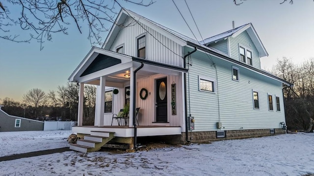 snow covered property featuring a porch