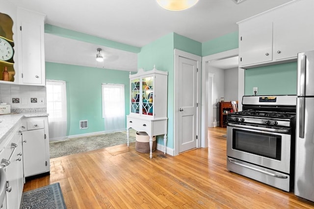 kitchen featuring tasteful backsplash, light hardwood / wood-style flooring, stainless steel appliances, and white cabinets