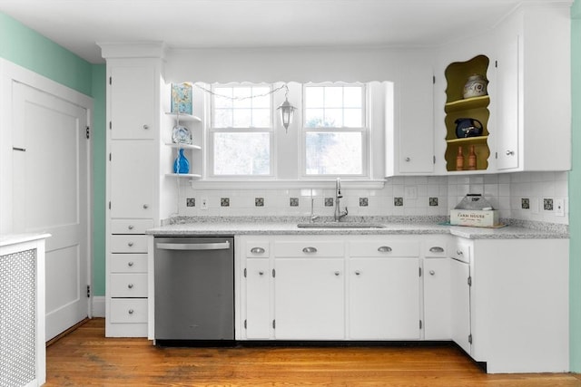 kitchen with sink, light hardwood / wood-style flooring, white cabinetry, backsplash, and stainless steel dishwasher