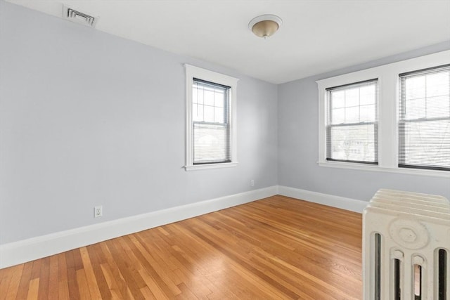 unfurnished room with radiator and hardwood / wood-style flooring