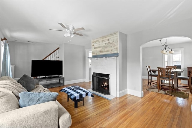 living room featuring hardwood / wood-style floors, a fireplace, and ceiling fan