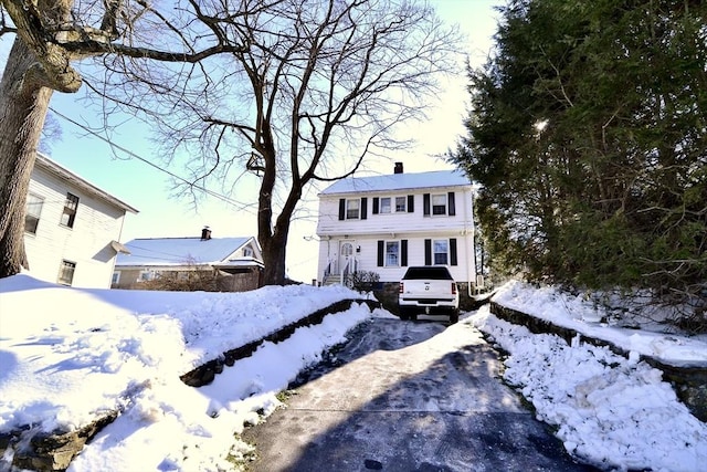 view of front of home featuring driveway and a chimney