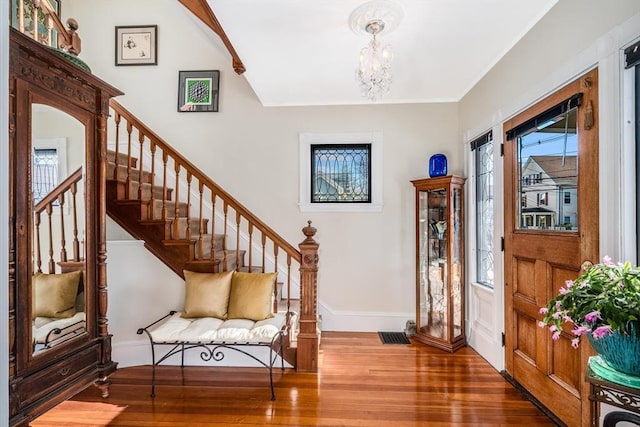 foyer entrance with wood-type flooring and an inviting chandelier