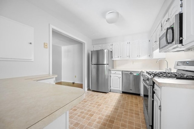 99 Apache Way Unit 99, Tewksbury, MA 01876 - kitchen featuring appliances with stainless steel finishes, white cabinets, light countertops, light floors, and baseboards