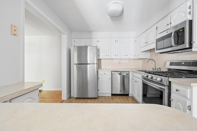 99 Apache Way Unit 99, Tewksbury, MA 01876 - kitchen featuring appliances with stainless steel finishes, a sink, white cabinetry, light countertops, and baseboards