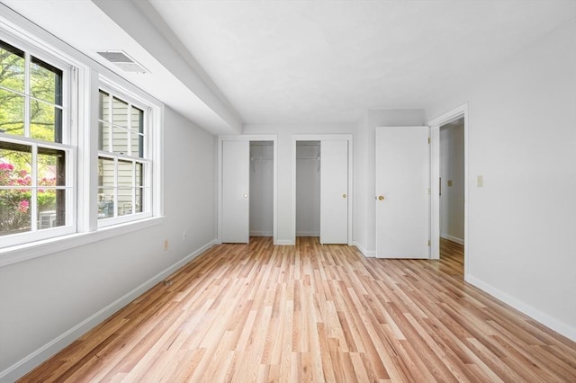 99 Apache Way Unit 99, Tewksbury, MA 01876 - unfurnished bedroom with multiple closets, light wood-type flooring, baseboards, and multiple windows