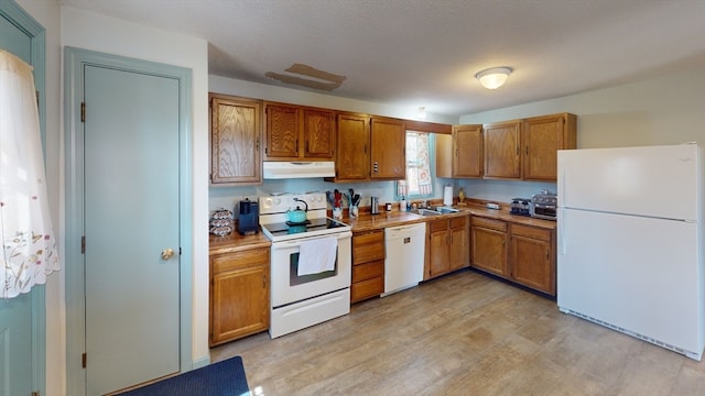 kitchen with light hardwood / wood-style flooring, a textured ceiling, sink, and white appliances