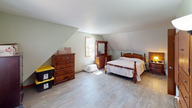 bedroom with light hardwood / wood-style floors and vaulted ceiling