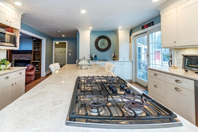 262 Homestead Ave, Rehoboth, MA 02769 - kitchen featuring white cabinets, recessed lighting, light stone counters, stainless steel appliances, and decorative columns