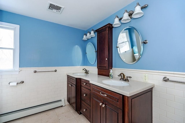 262 Homestead Ave, Rehoboth, MA 02769 - bathroom featuring a baseboard radiator, tile walls, wainscoting, double vanity, and tile patterned floors