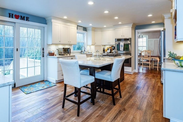 262 Homestead Ave, Rehoboth, MA 02769 - kitchen featuring stainless steel appliances, dark wood-type flooring, white cabinets, a breakfast bar area, and recessed lighting