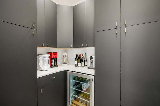 bar with gray cabinetry, wine cooler, and decorative backsplash