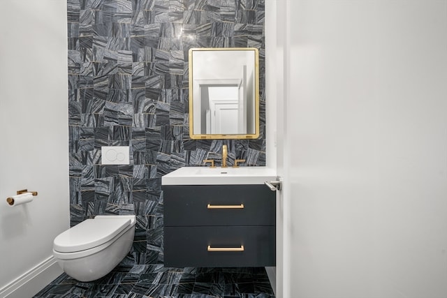 bathroom with tile walls, vanity, and toilet