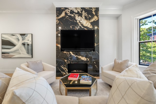 living room featuring a healthy amount of sunlight, ornamental molding, and a high end fireplace