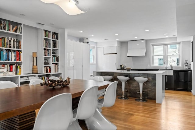 dining room featuring light wood-style floors, recessed lighting, and a barn door