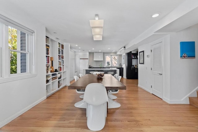 dining space featuring light wood finished floors, baseboards, and recessed lighting