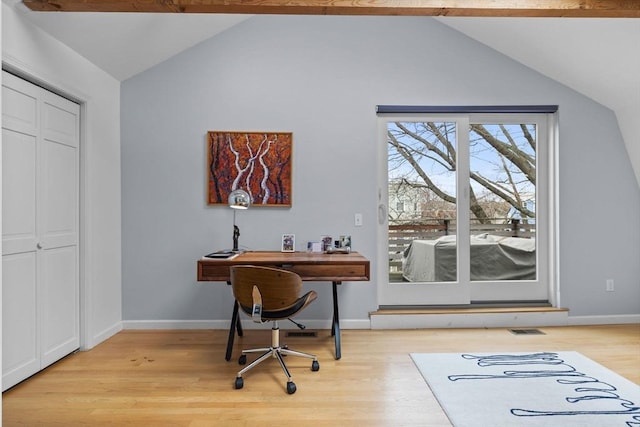 office space featuring lofted ceiling with beams, light wood finished floors, baseboards, and visible vents