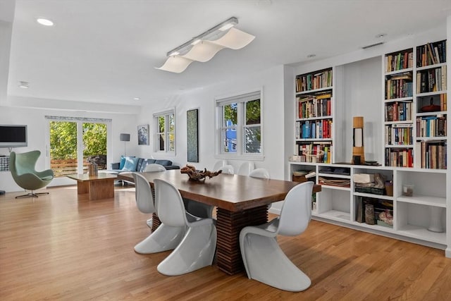 dining space with built in features and wood finished floors