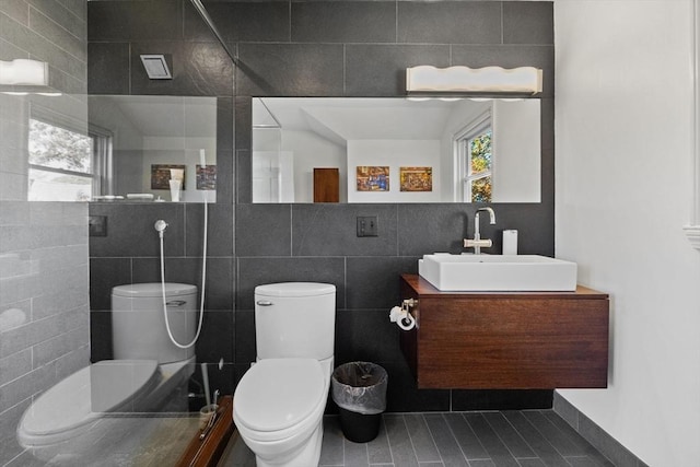 bathroom featuring tile walls, vanity, and toilet