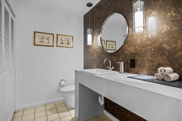 bathroom featuring tile patterned flooring, a closet, a sink, and toilet