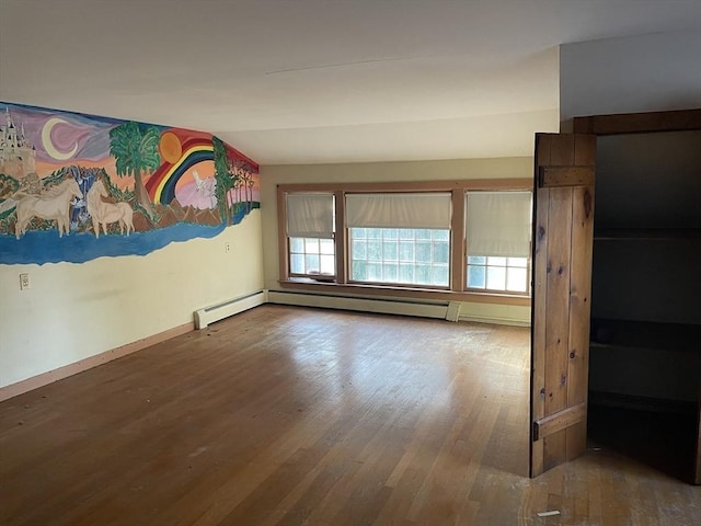 empty room with hardwood / wood-style floors and vaulted ceiling