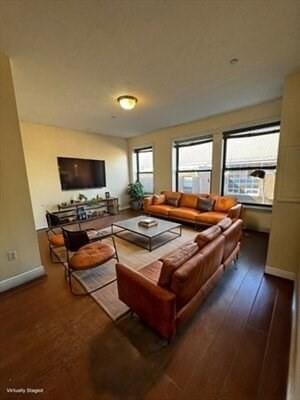 living area with baseboards and wood finished floors