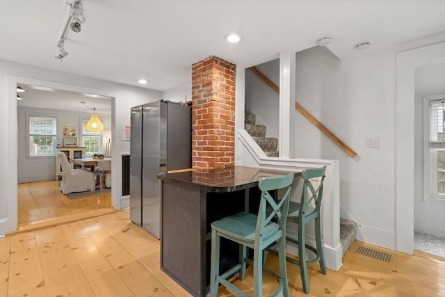 11 Congress St, Newburyport, MA 01950 - kitchen with freestanding refrigerator, light wood-style floors, track lighting, a breakfast bar area, and dark stone counters