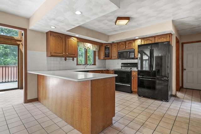 3 Westview Ter, Woburn, MA 01801 - kitchen featuring black appliances, a peninsula, brown cabinets, light tile patterned floors, and recessed lighting