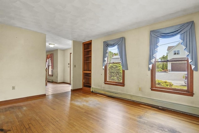 3 Westview Ter, Woburn, MA 01801 - empty room featuring a baseboard radiator, wood-type flooring, and baseboards