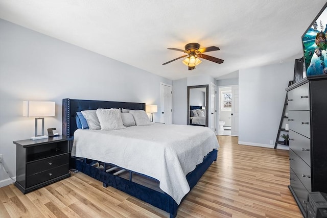 bedroom with connected bathroom, a ceiling fan, light wood-type flooring, and baseboards