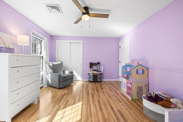 game room featuring baseboards, light wood-style floors, visible vents, and ceiling fan