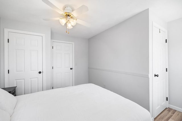 bedroom with baseboards, a ceiling fan, and wood finished floors