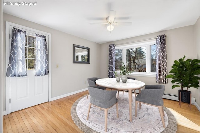 dining room with baseboards, light wood-type flooring, baseboard heating, and ceiling fan