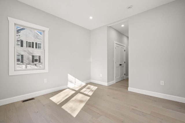 empty room featuring baseboards, visible vents, recessed lighting, and light wood-style floors
