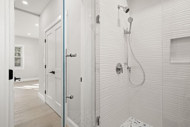 bathroom featuring baseboards, wood finished floors, recessed lighting, and a shower stall
