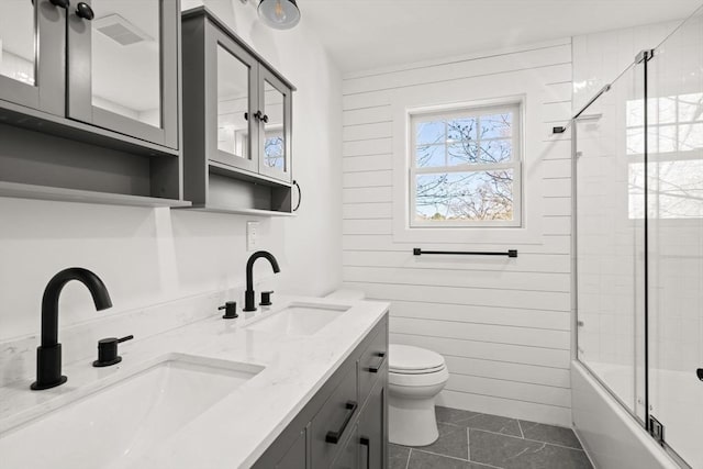 bathroom with toilet, tile patterned flooring, a sink, and double vanity