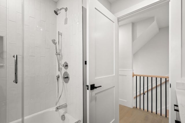 bathroom with bathing tub / shower combination and wood finished floors