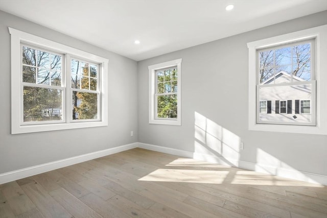 spare room featuring hardwood / wood-style flooring, baseboards, and recessed lighting