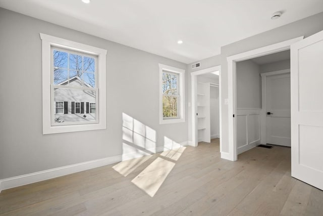 interior space featuring baseboards, light wood-style floors, visible vents, and recessed lighting