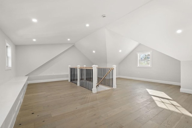 bonus room with baseboards, vaulted ceiling, light wood finished floors, and recessed lighting